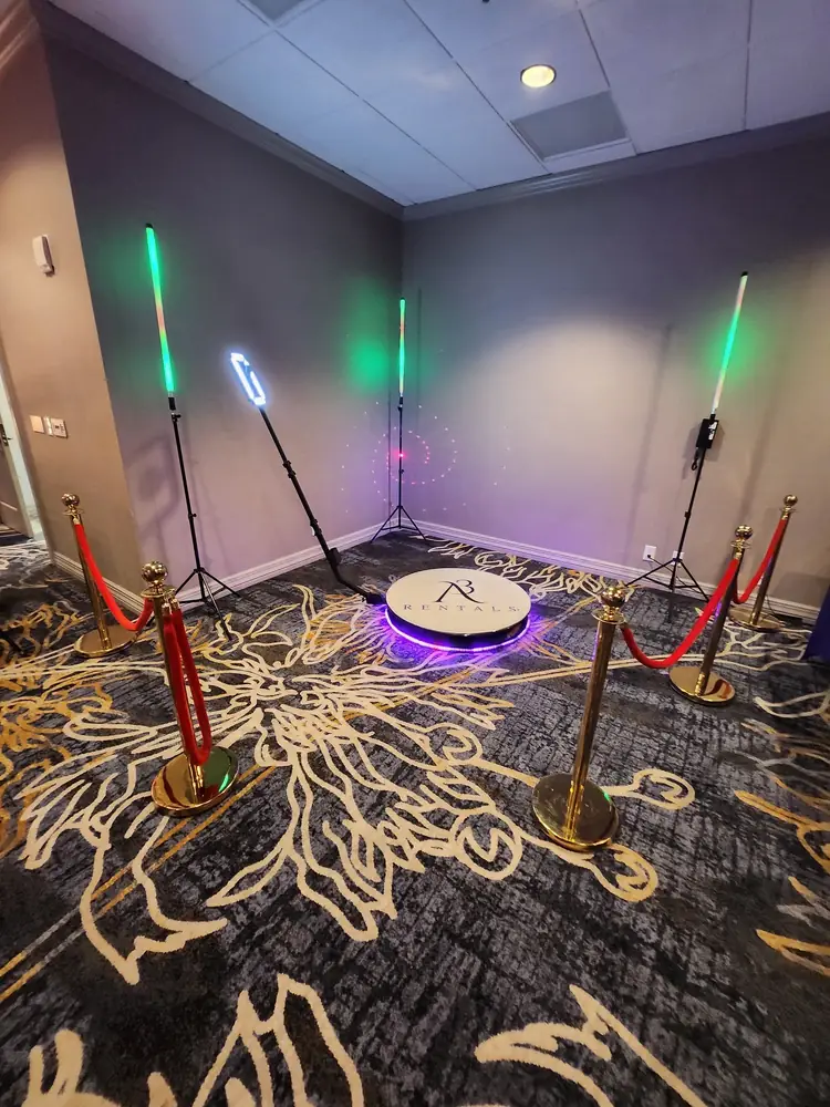 A3 Rentals 360 photo booth platform with purple LED lighting, light sticks and gold stanchions